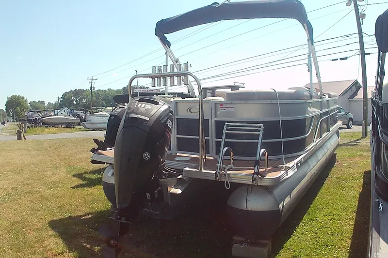 Slide: The Image of 2015 Crest 230 bar pontoon boat with outboard motor on grassy lot. - 3