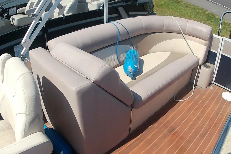 Slide: The Image of 2015 Crest 230 bar boat interior with beige seating and wooden deck. - 8
