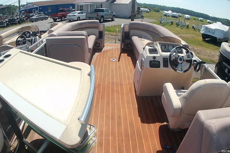 Slide: The Image of Interior of a 2015 Crest 230 Bar pontoon boat with plush seating and wooden flooring. - 9