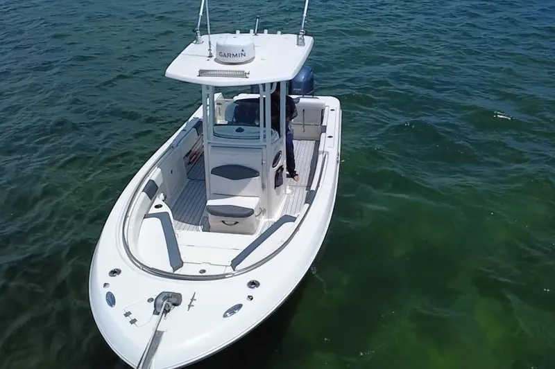 Slide: The Image of 2019 Robalo R242 Center Console boat on clear blue water. - 12