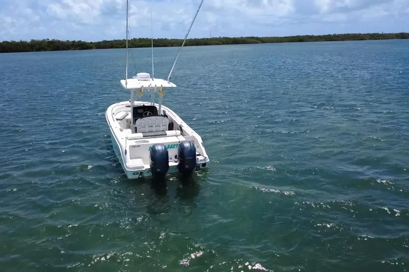 Slide: The Image of 2019 Robalo R242 Center Console boat on calm water, clear sky background. - 15