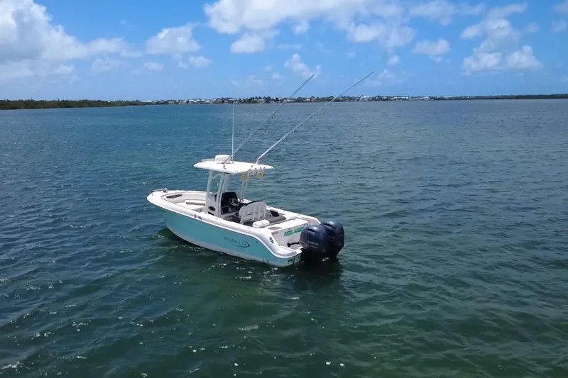 Slide: The Image of 2019 Robalo R242 Center Console boat on calm water under blue sky. - 16