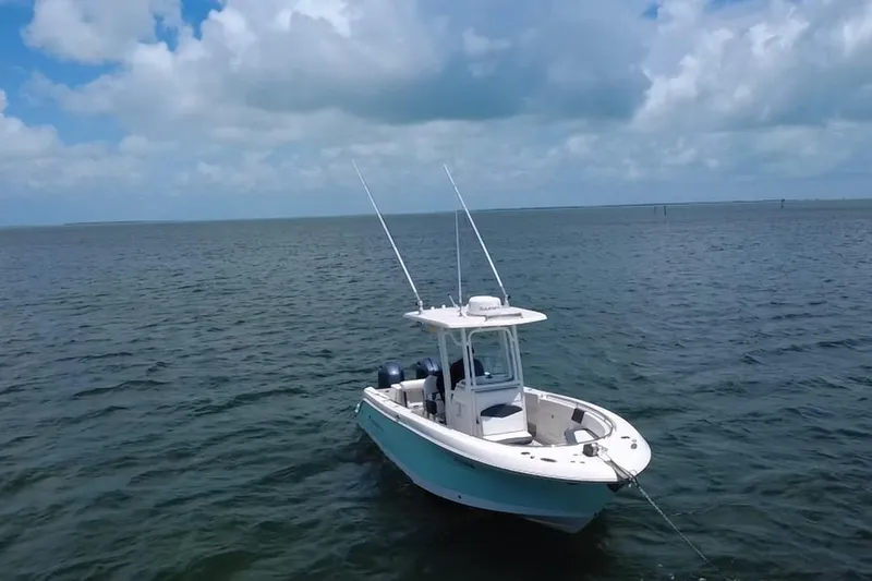 Slide: The Image of 2019 Robalo R242 Center Console boat on open water under cloudy sky. - 19
