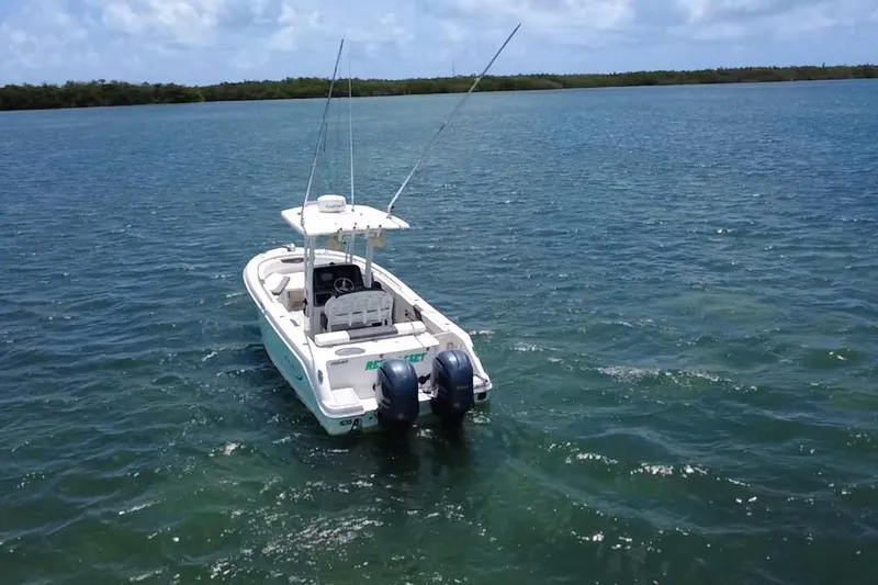 Slide: The Image of 2019 Robalo R242 Center Console boat on open water, featuring dual engines. - 2