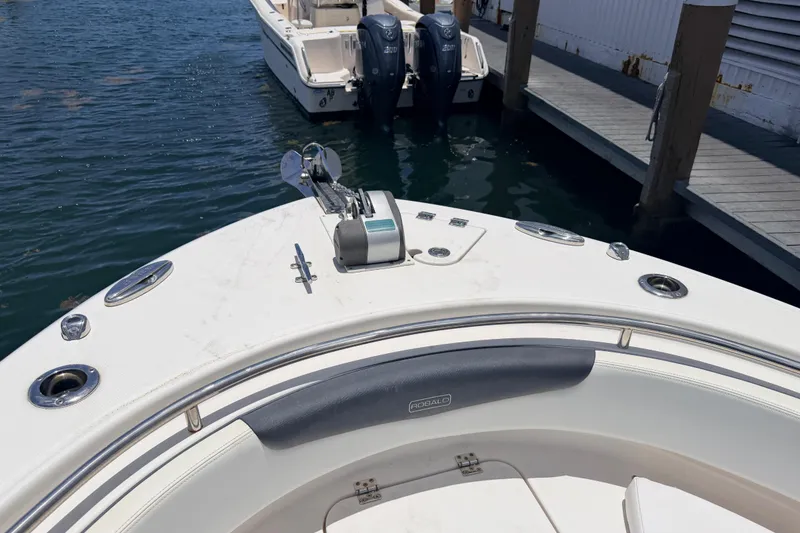 Slide: The Image of 2019 Robalo R242 Center Console boat docked, featuring anchor and seating area. - 26