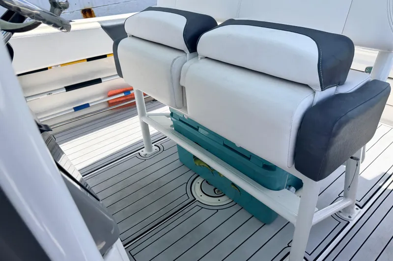 Slide: The Image of 2019 Robalo R242 Center Console boat interior with cushioned seating and storage. - 36