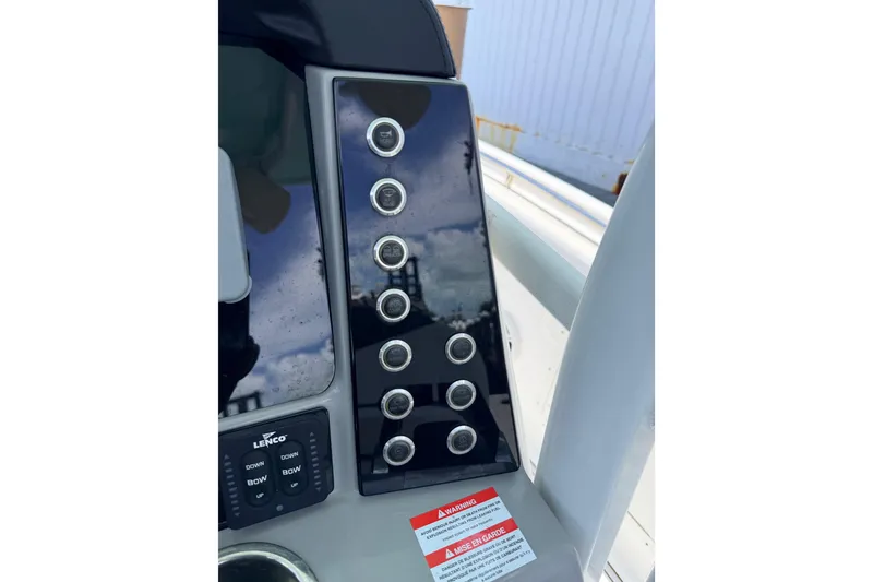Slide: The Image of Control panel of 2019 Robalo R242 Center Console boat with switches and warning label. - 37