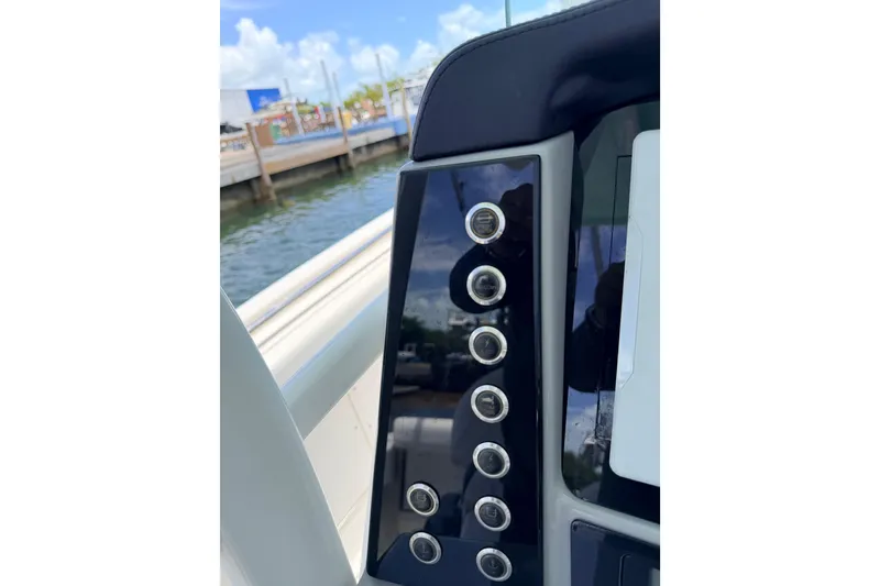 Slide: The Image of Control panel of a 2019 Robalo R242 Center Console boat by the water. - 38