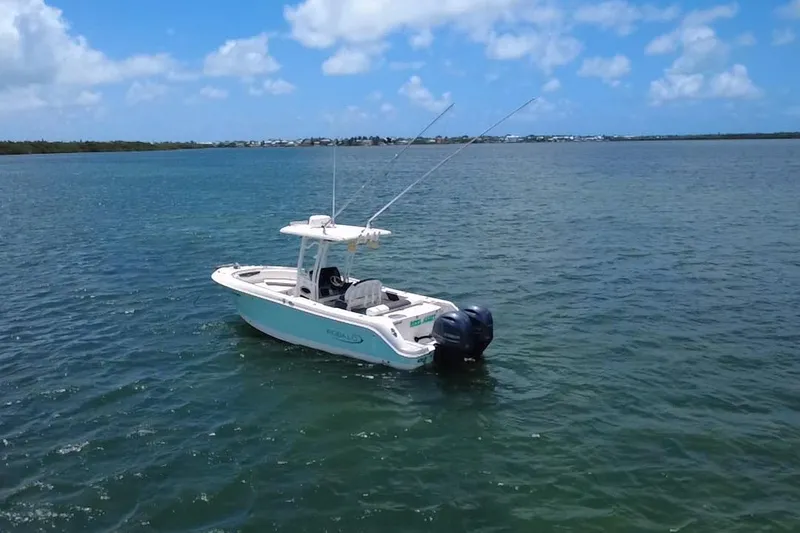Slide: The Image of 2019 Robalo R242 Center Console boat on calm blue water under clear sky. - 4