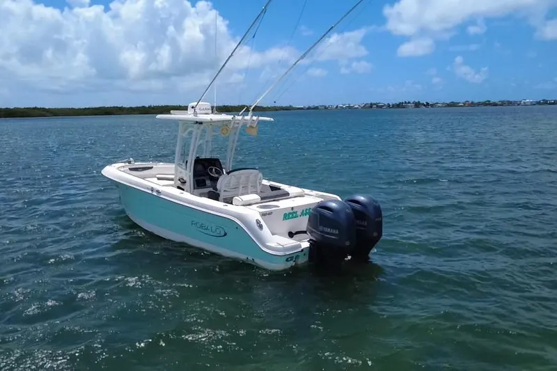 Slide: The Image of 2019 Robalo R242 Center Console boat on calm water under blue sky. - 5