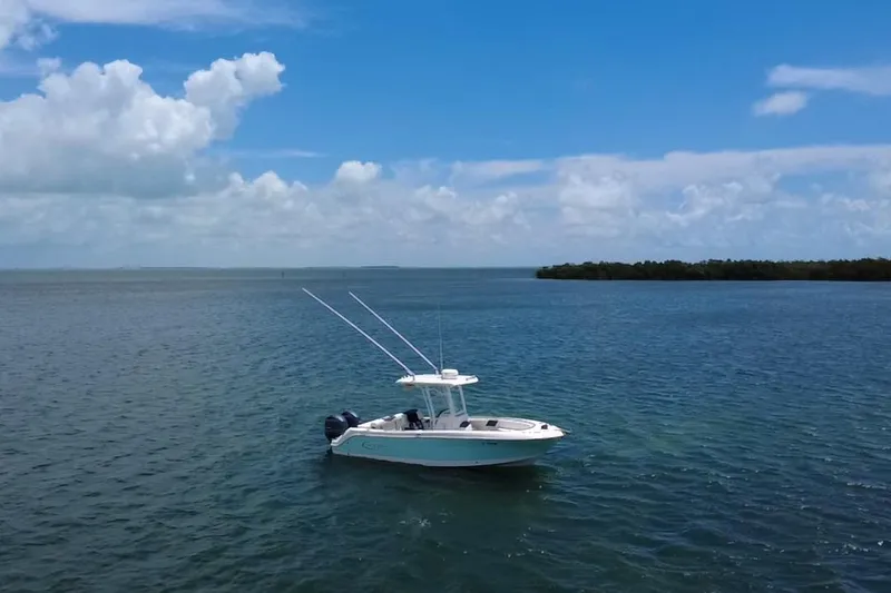 Slide: The Image of 2019 Robalo R242 Center Console boat on calm blue water under a clear sky. - 6