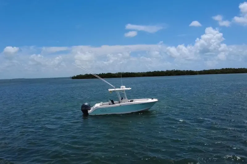 Slide: The Image of 2019 Robalo R242 Center Console boat on calm blue water under a clear sky. - 7