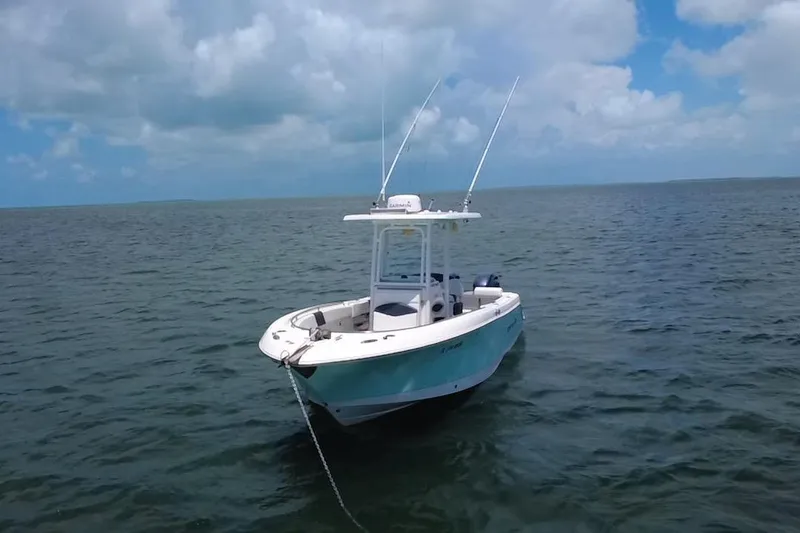 Slide: The Image of 2019 Robalo R242 Center Console boat anchored on calm ocean waters under a cloudy sky. - 8