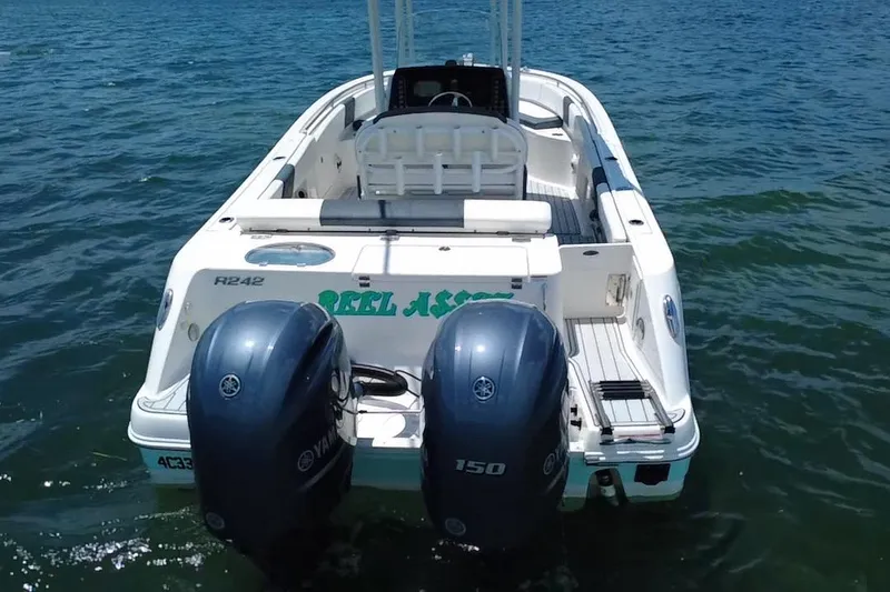 Slide: The Image of 2019 Robalo R242 Center Console boat with dual Yamaha engines on water. - 9