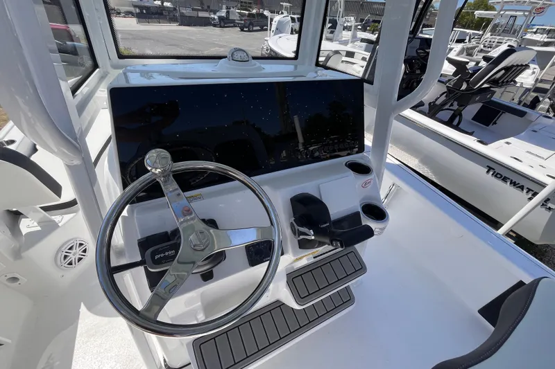 Slide: The Image of 2026 Tidewater 2210 Carolina Bay boat console with steering wheel and controls. - 11