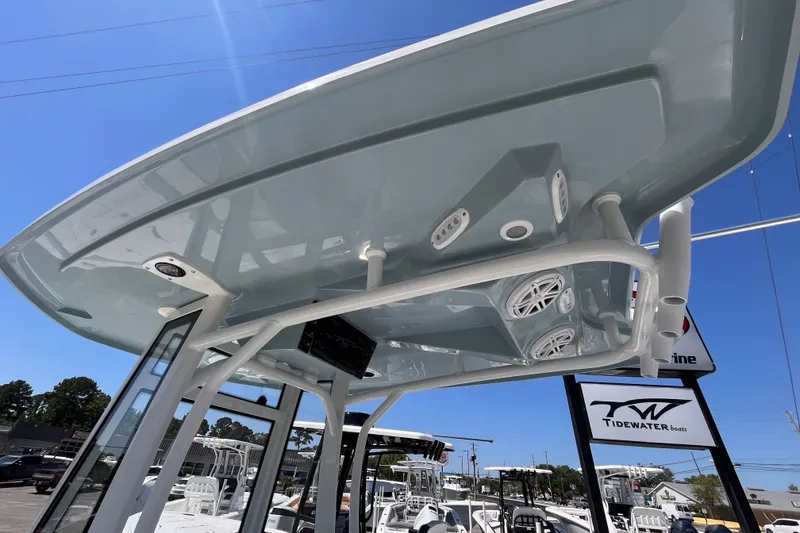 Slide: The Image of 2026 Tidewater 2210 Carolina Bay boat with T-top and speakers, displayed outdoors. - 12