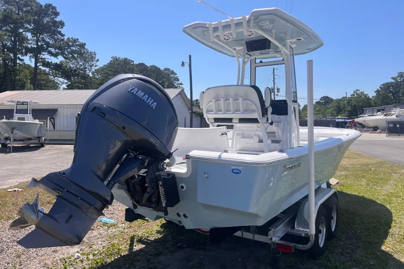 Slide: The Image of 2026 Tidewater 2210 Carolina Bay boat with Yamaha engine on trailer, parked outdoors. - 3