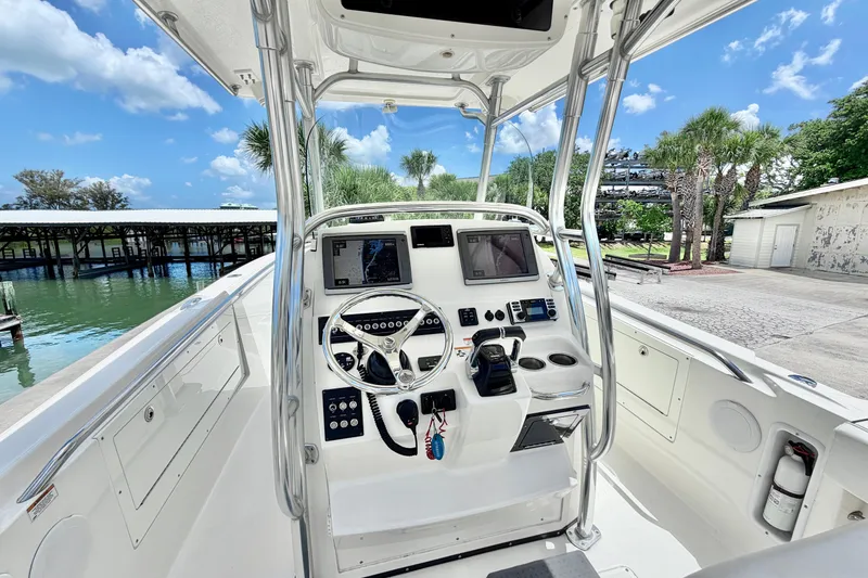 Slide: The Image of 2013 Edgewater 318CC boat cockpit with steering wheel, navigation screens, and controls. - 1