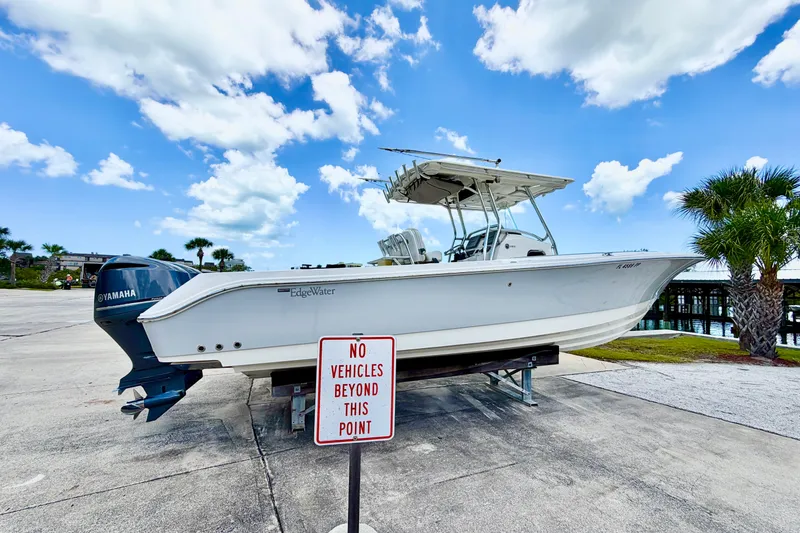 Slide: The Image of Edgewater 318CC 2013 boat on trailer, Yamaha engine, clear sky, "No Vehicles Beyond This Point" sign. - 10