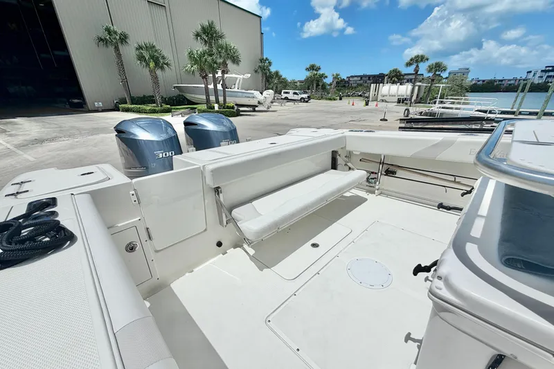 Slide: The Image of 2013 Edgewater 318CC boat with dual engines, docked near palm trees and a marina. - 11