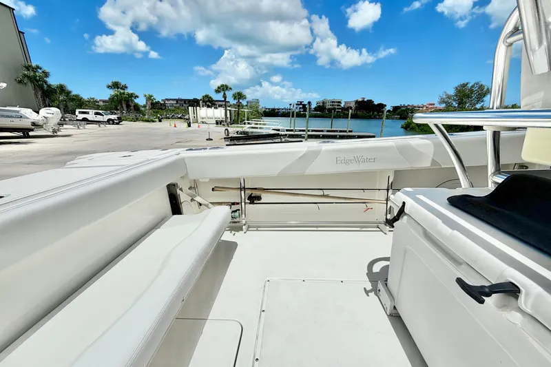 Slide: The Image of 2013 Edgewater 318CC boat interior with seating, dockside view, and clear blue sky. - 12