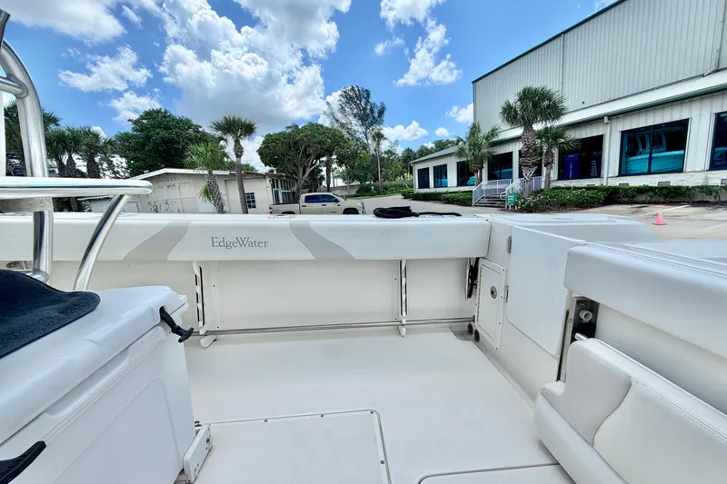 Slide: The Image of 2013 Edgewater 318CC boat interior with white seating, outdoors under blue sky. - 14