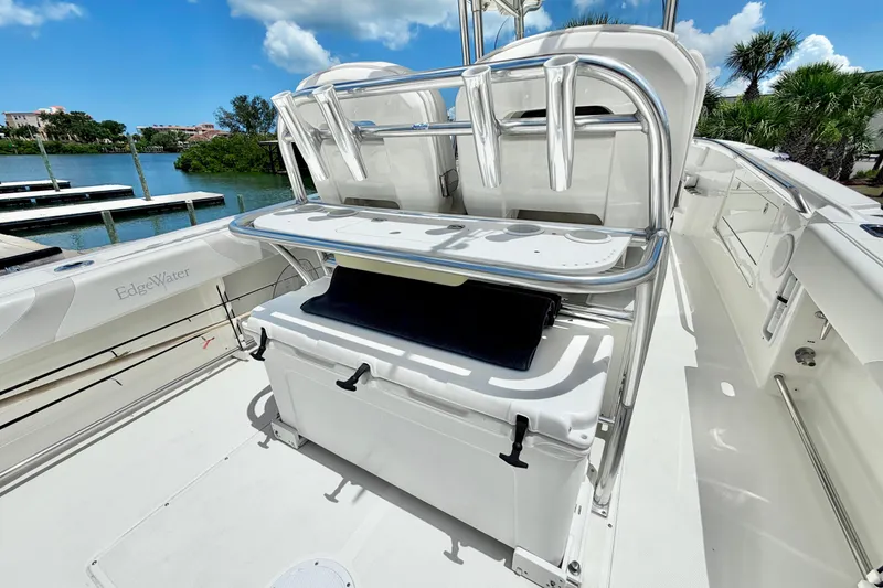 Slide: The Image of 2013 Edgewater 318CC boat interior with seating and storage, dockside view. - 15