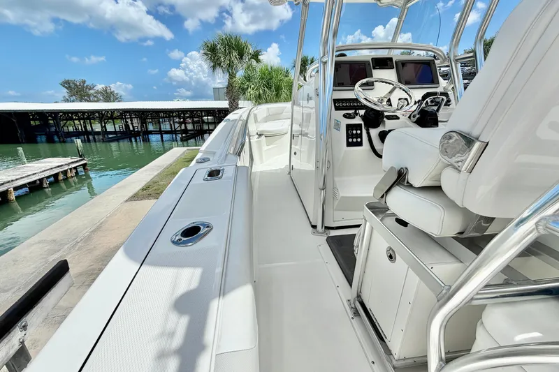 Slide: The Image of 2013 Edgewater 318CC boat interior with helm, dockside view, and clear blue sky. - 16