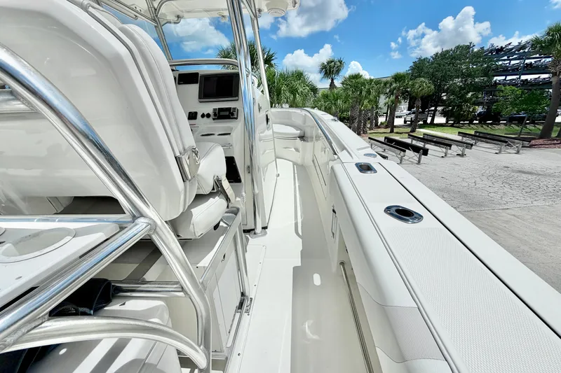 Slide: The Image of 2013 Edgewater 318CC boat interior with white seating and chrome details under a blue sky. - 17