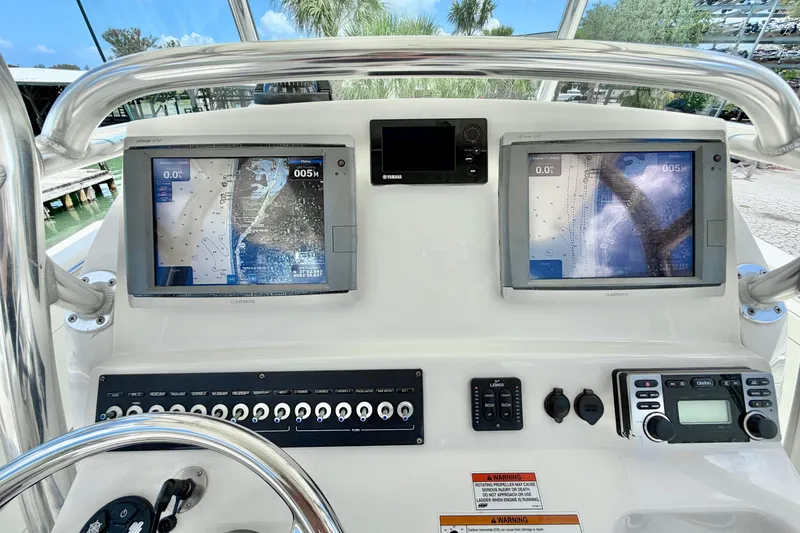Slide: The Image of Edgewater 318CC 2013 boat dashboard with dual Garmin navigation screens and controls. - 18