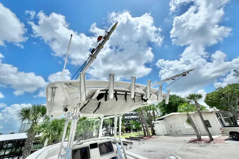 Slide: The Image of Edgewater 318CC boat, 2013 model, with fishing rods under a bright blue sky. - 19