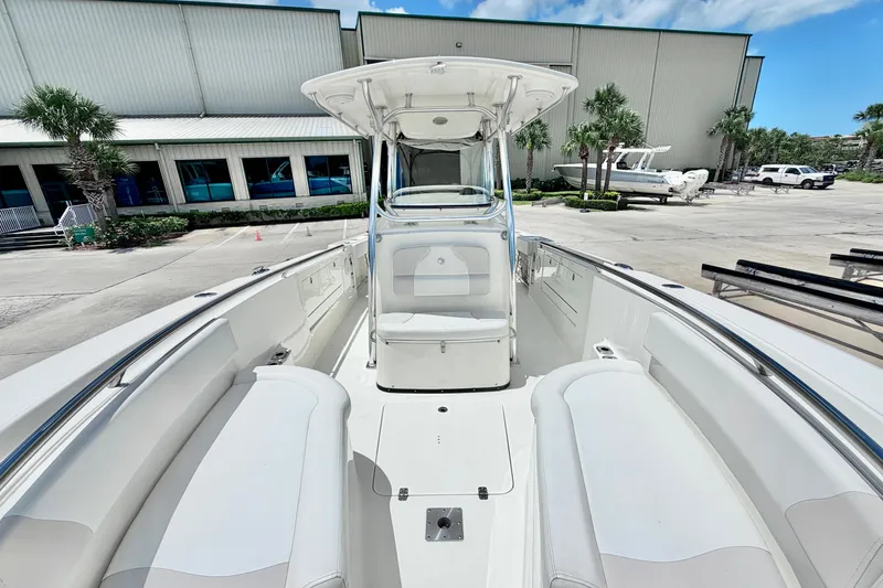Slide: The Image of 2013 Edgewater 318CC boat interior with seating, docked near a building. - 22