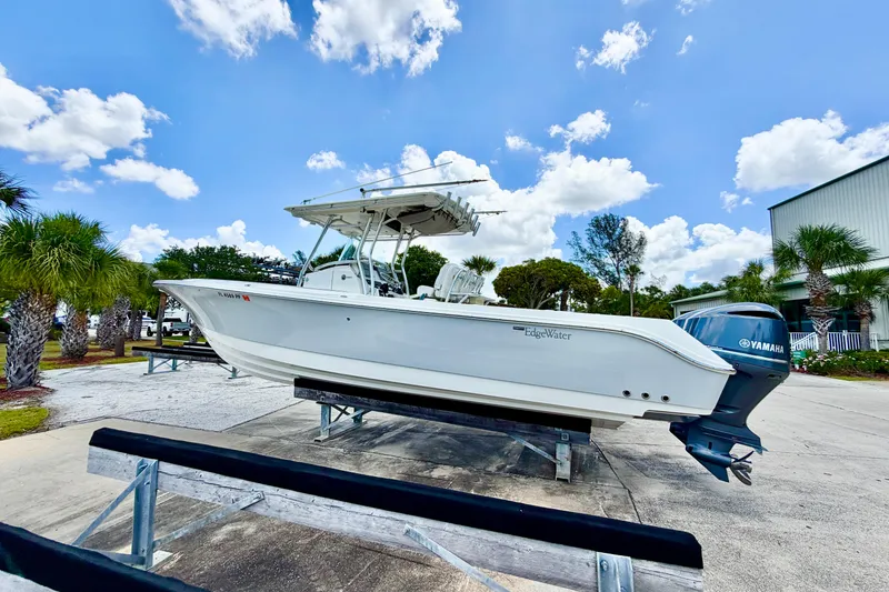 Slide: The Image of 2013 Edgewater 318CC boat on display with Yamaha engine, under a clear blue sky. - 6