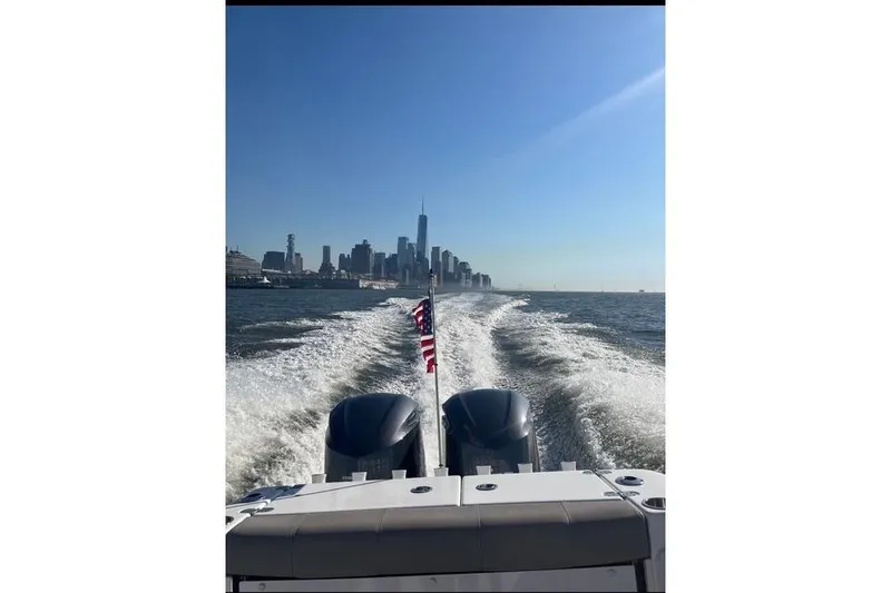 Slide: The Image of 2021 Cape Horn 32 XS boat cruising with city skyline in the background. - 3
