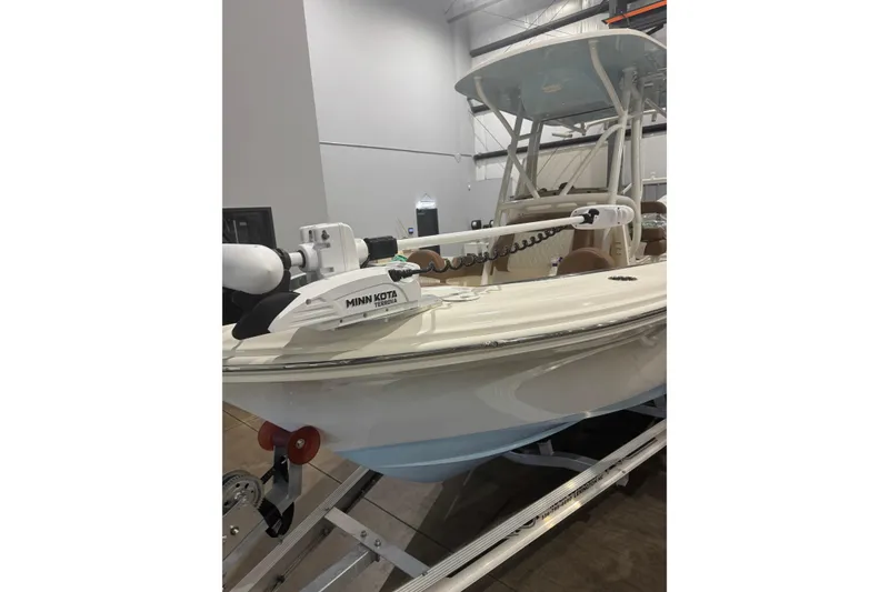 Slide: The Image of 2023 Pioneer 202 Islander boat with Minn Kota Terrova motor, displayed indoors on a trailer. - 1