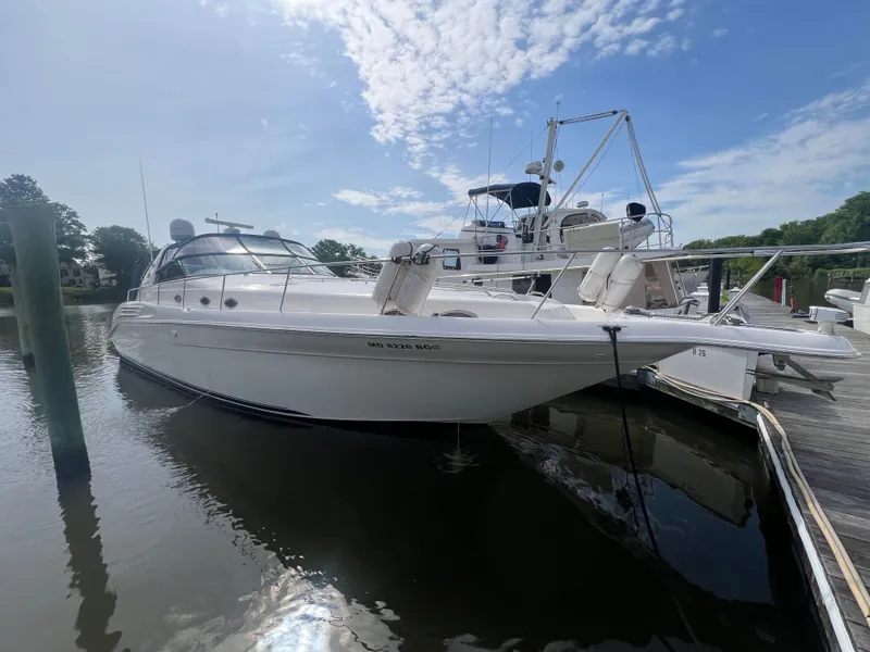 The Image of 1997 Sea Ray 450 yacht docked in sunny harbor. - 0