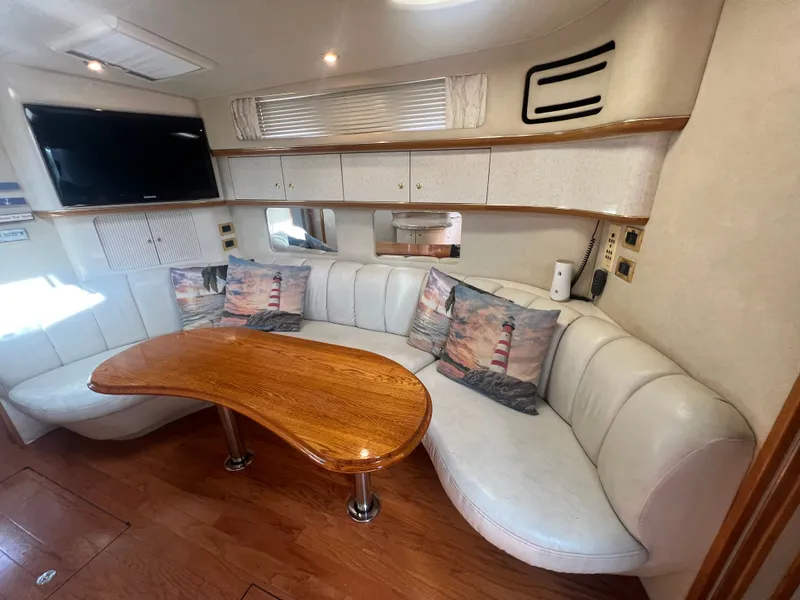 Slide: The Image of Interior of a 1997 Sea Ray 450 yacht with white sofa and wooden table. - 26