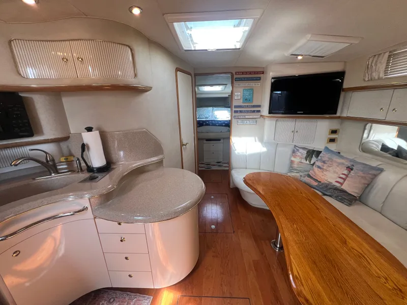 Slide: The Image of Interior of a 1997 Sea Ray 450 yacht with kitchen and seating area. - 28