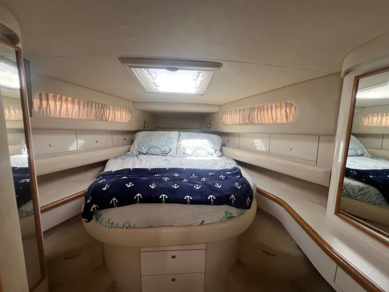 Slide: The Image of Interior of a 1997 Sea Ray 450 yacht featuring a cozy bedroom. - 29