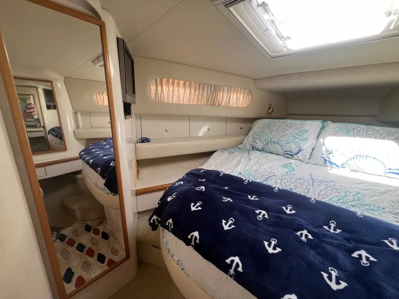 Slide: The Image of Interior of a 1997 Sea Ray 450 yacht featuring a cozy bedroom. - 31