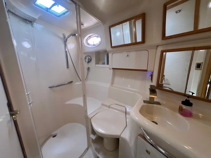 Slide: The Image of Sea Ray 450 yacht interior, bathroom with shower, mirrors, and sink. - 33