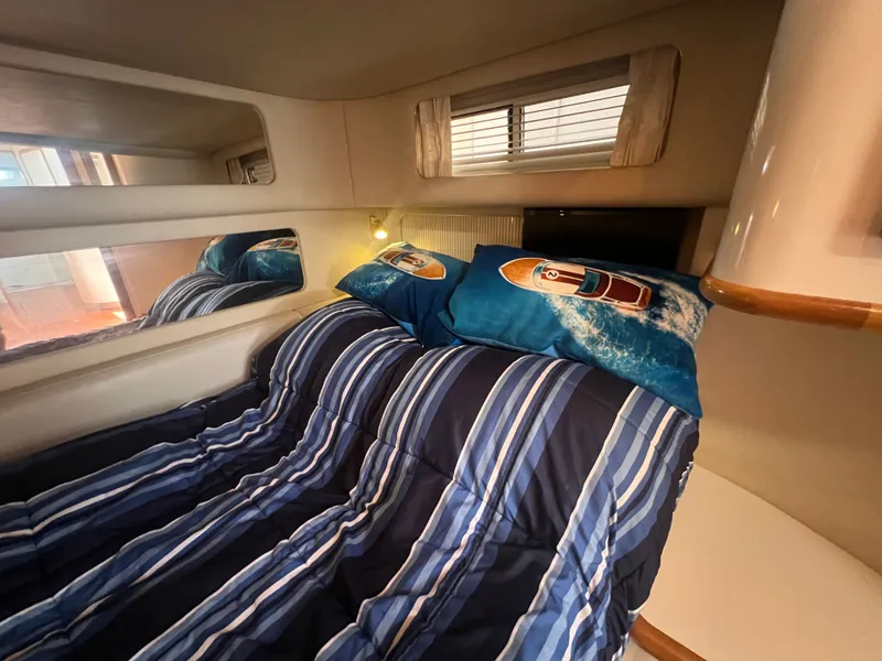 Slide: The Image of Interior of a 1997 Sea Ray 450 yacht with striped bedding. - 43