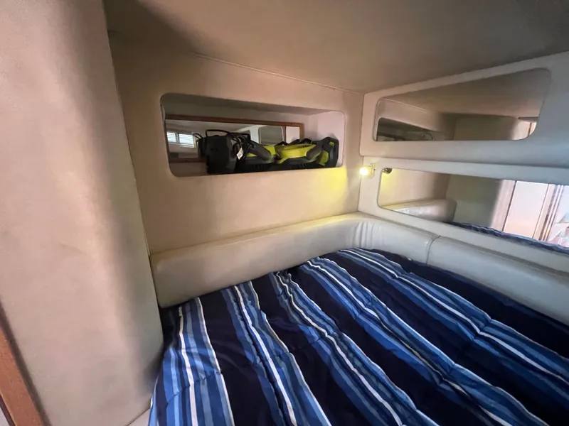 Slide: The Image of Interior of a 1997 Sea Ray 450 yacht with striped bedding. - 45