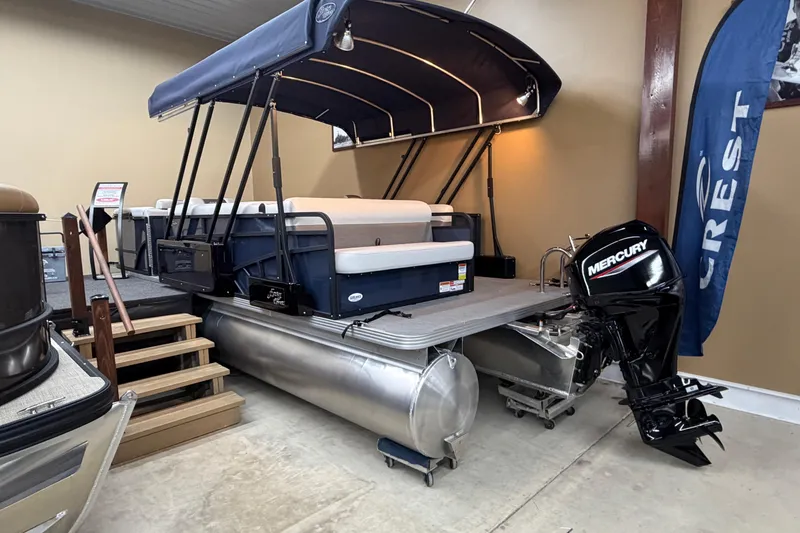 Slide: The Image of 2026 Crest Conquest SE 220 Cruise pontoon boat with Mercury outboard motor in showroom. - 9