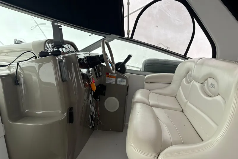 Slide: The Image of Interior of 1999 Four Winns 328 Vista boat with steering wheel and white seating. - 10
