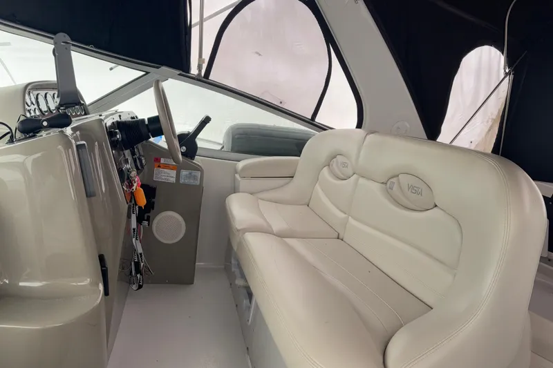 Slide: The Image of 1999 Four Winns 328 Vista boat interior with white leather seating and steering console. - 11