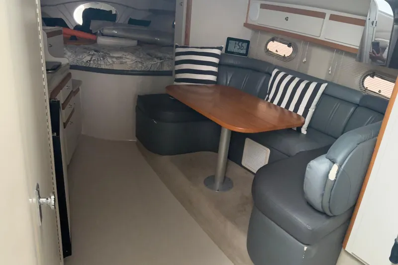 Slide: The Image of 1999 Four Winns 328 Vista cabin interior with dining area and cozy seating. - 17