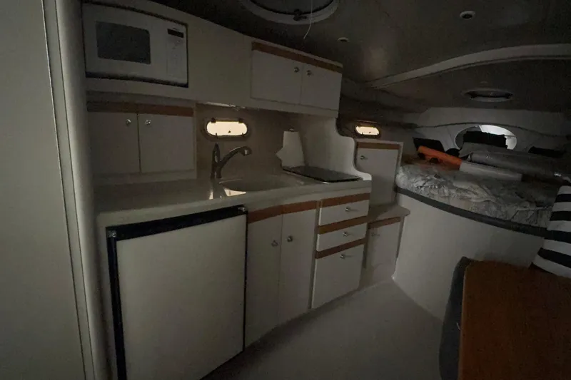 Slide: The Image of Interior of 1999 Four Winns 328 Vista boat, featuring kitchenette and sleeping area. - 19