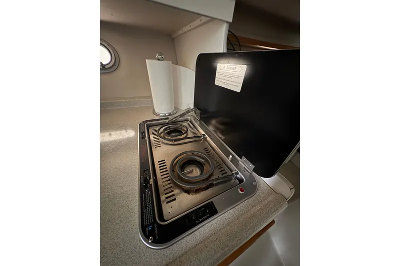Slide: The Image of 1999 Four Winns 328 Vista boat kitchen with two-burner stove and paper towel holder. - 23