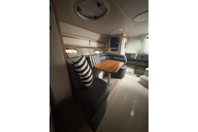 Slide: The Image of Interior of 1999 Four Winns 328 Vista boat with cozy seating and striped cushions. - 25